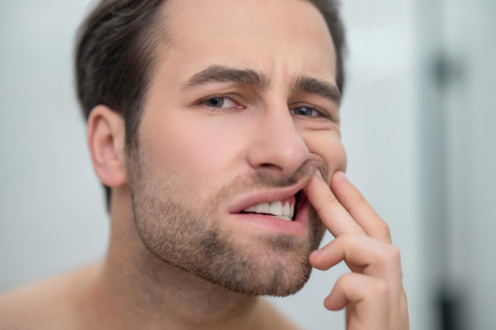 homem olhando no espelho e vendo se tem tártoro no dente